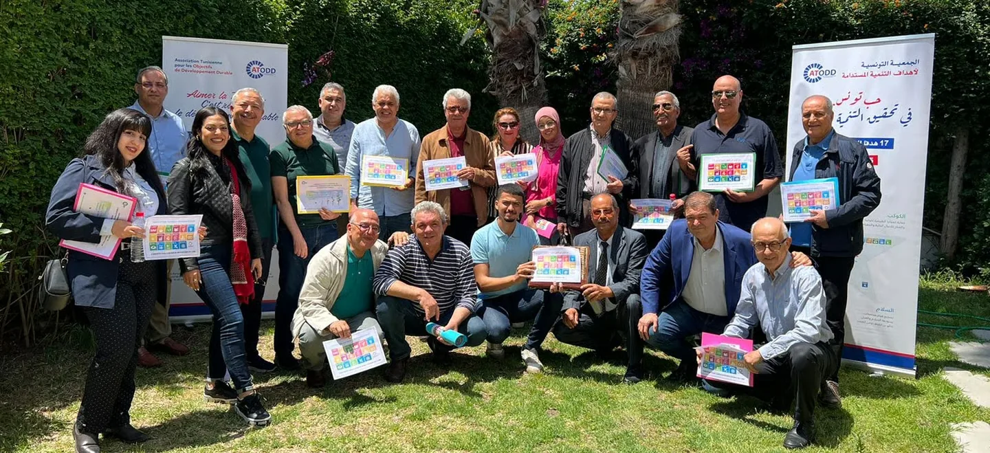 Les membres de l’ATODD réunis en plein air avec la bannière de l’association